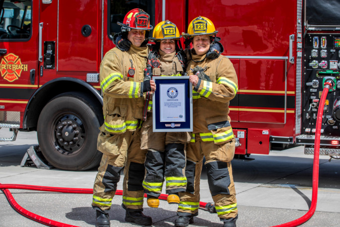 Two crewmates holding Autumn and her certificate