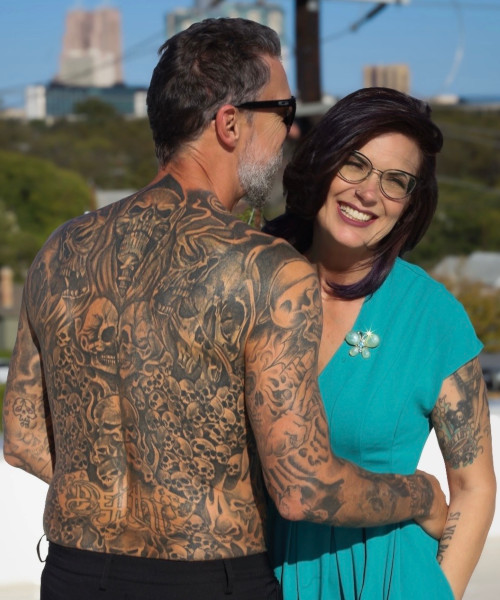 Scott shirtless on the beach with his wife