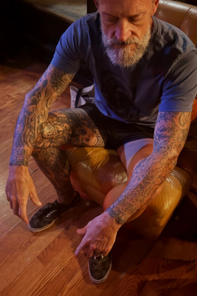 Scott sitting, with a full shot of his tattoos