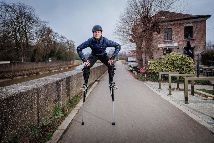Jonathan crouching while wearing his stilts