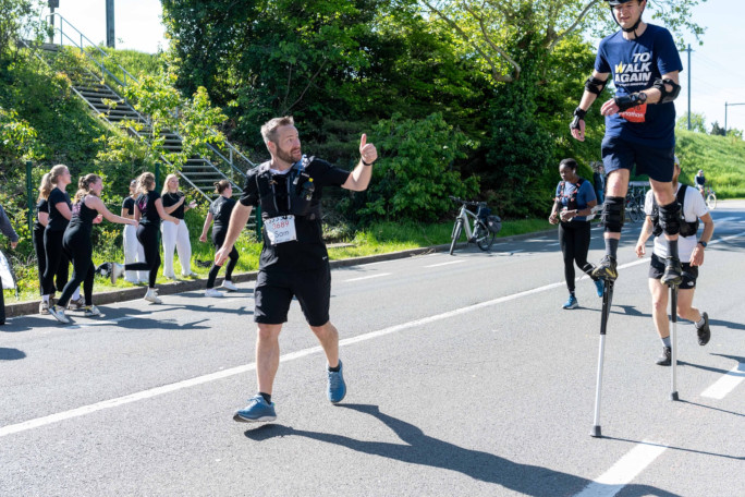 Another racer giving Jonathan a thumbs up during his stilt marathon
