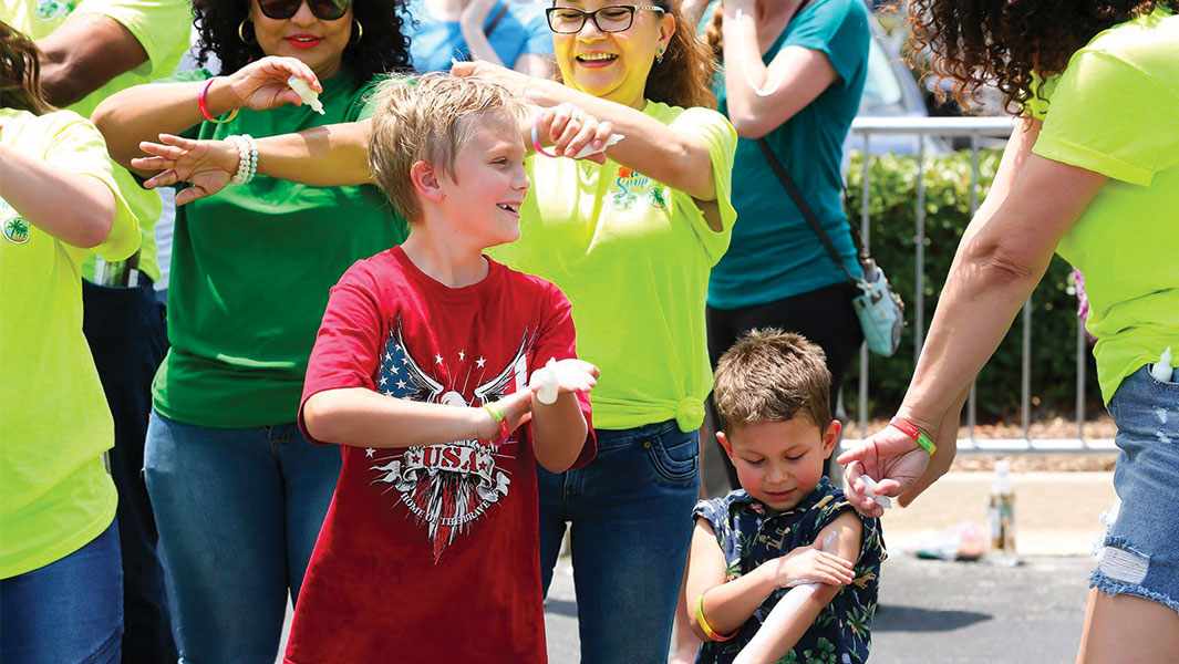 Kids applying sun screen during record attempt