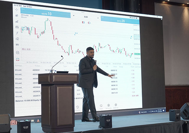 Instructor on stage while giving a lesson about trading