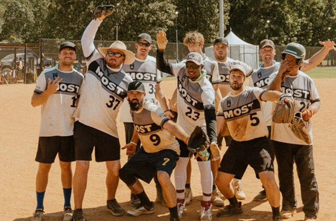a group of men wearing sporting gear pose in a field