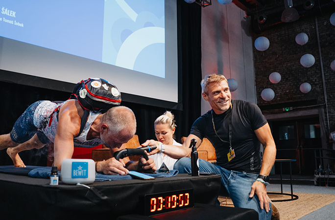 three people are besides Josef while he holds his planking position