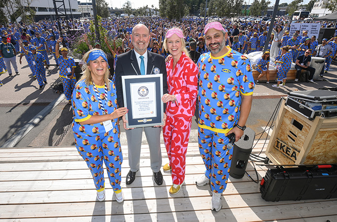 four people smile holding a guinness world records certificate