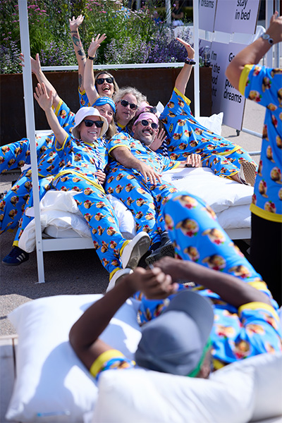 ikea employees lay on massive mattress wearing two piece pajamas