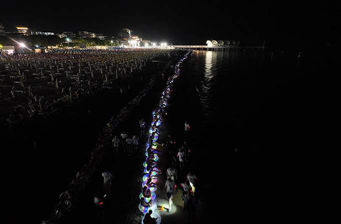 participants sat on the beach wearing floaties