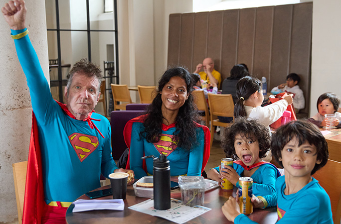 a family of four dressed in superman costumes