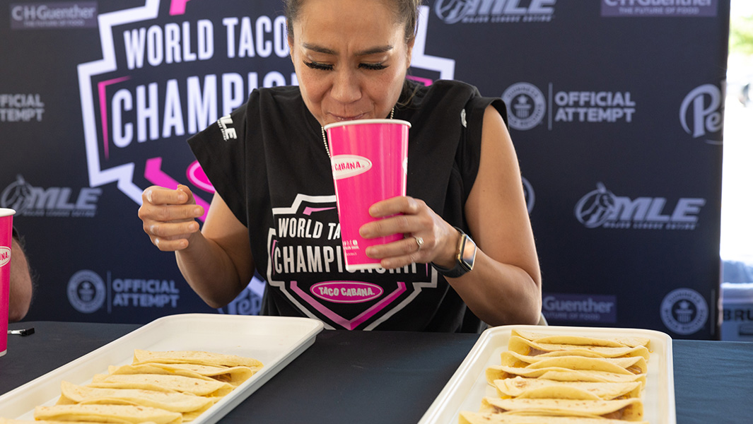 a woman drinks from a pink cup