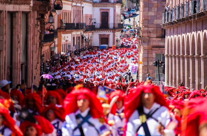 Participants in their hats walking down the street