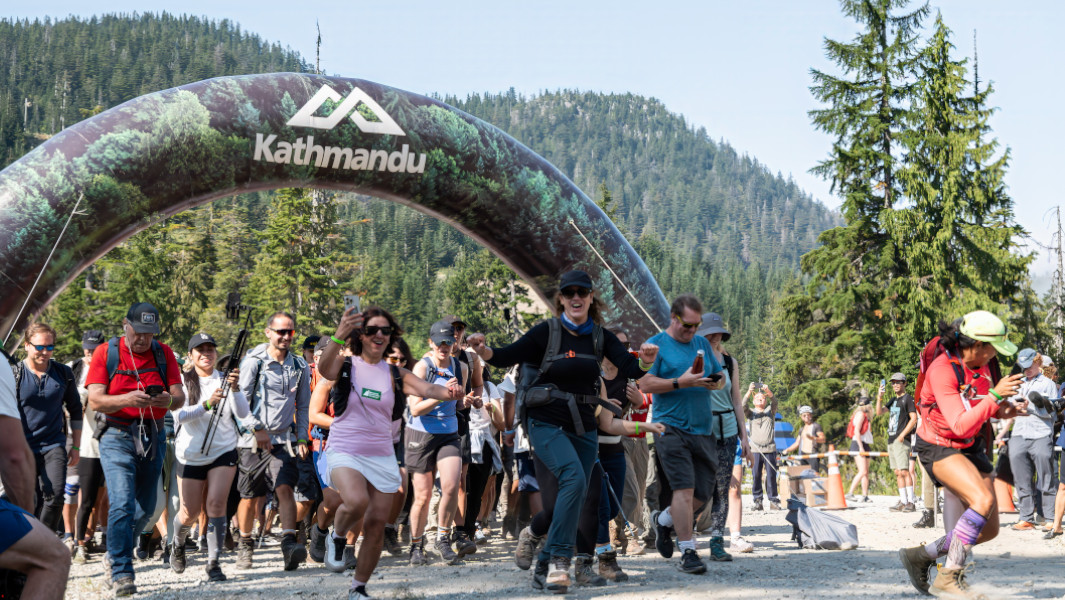 Hikers running through the entrance of the trek