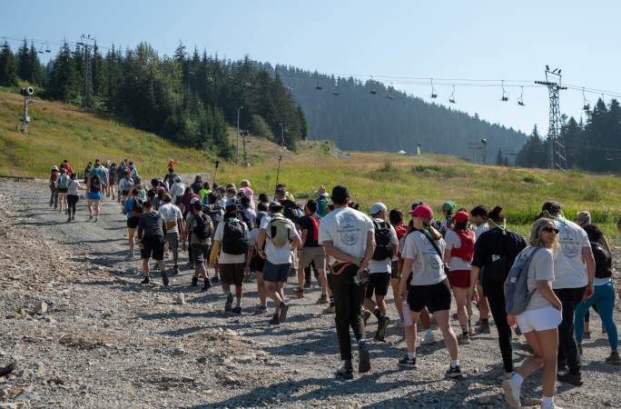 Pack of people walking up a mountain