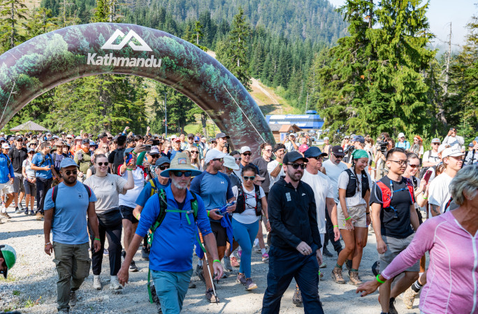 People walking under the Kathmandu banner