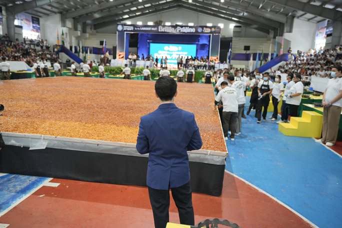 Official adjudicator looking over the largest nut brittle/praline