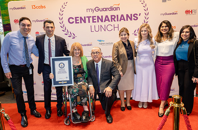 a group of people dressed in formal clothes stand in front of the guinness world records certificiate