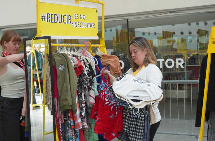A woman holding clothes at the rack