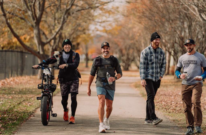 Mark walking next to the biker and his coaches