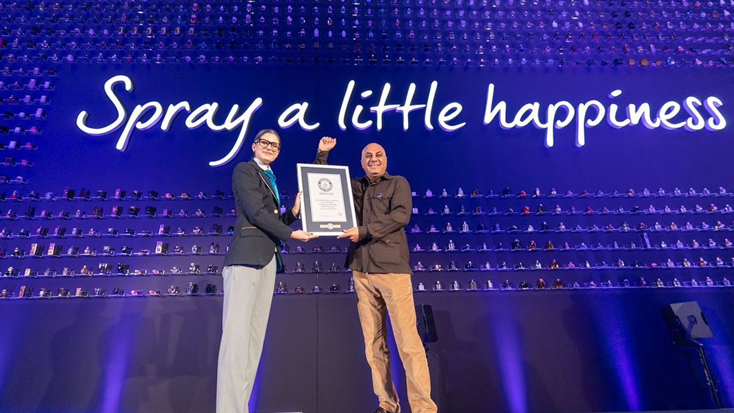 a female guinness world records adjudicator presents a guinness world records certificate to a man on stage