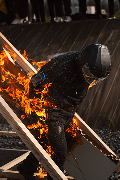 renaud emerges from the other side of the flaming door