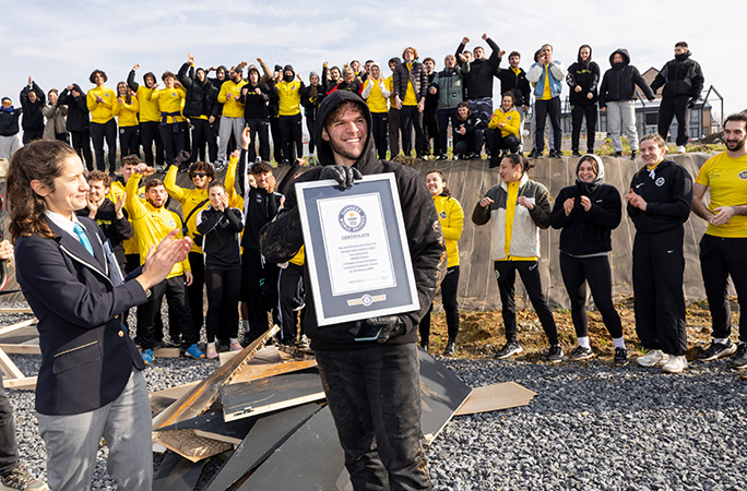 a smiling renaud holds up his guinness world records certificate