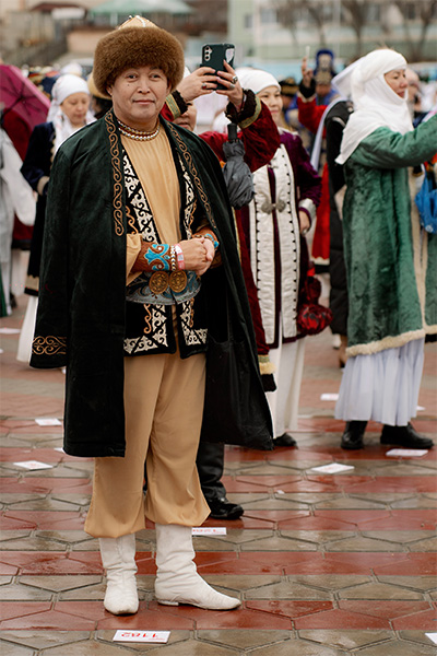 a man stands dressed in traditional kazakh clothing