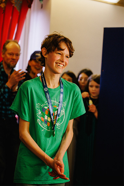 micah wearing a green t shirt smiles