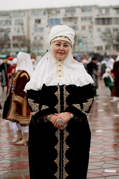 a woman standing in traditional kazakh clothing