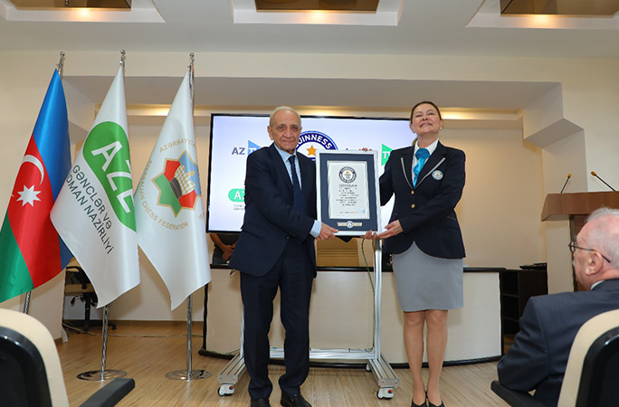 faig gasanov stands next to guinness world records adjudicator holding certificate