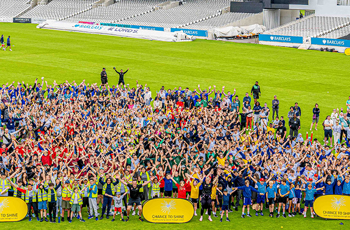 participants cheer with their arms up in front of yellow chance to shine signs