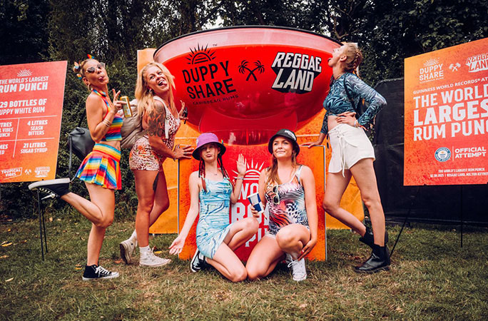 skupina návštěvníků festivalu pózuje vedle největšího alkoholického punče