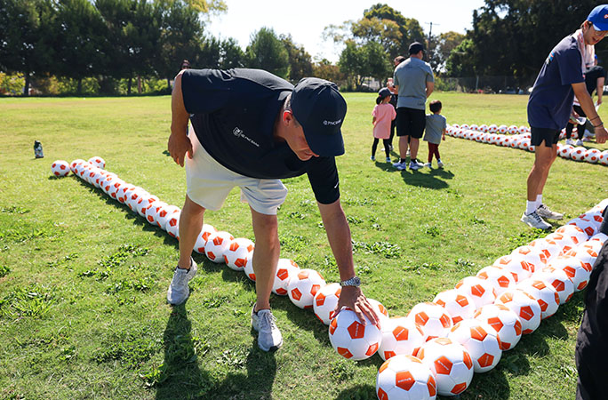 a man places soccer balls in the sentence formation