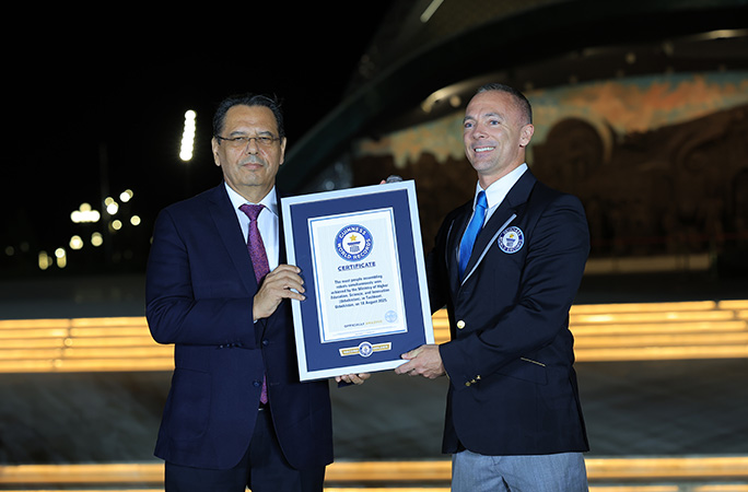 two men standing next together one is presented the guinness world records certificate