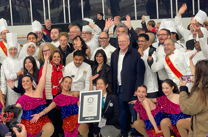 the pastry chef pose for a picture with performers and the guinness world records certificiate