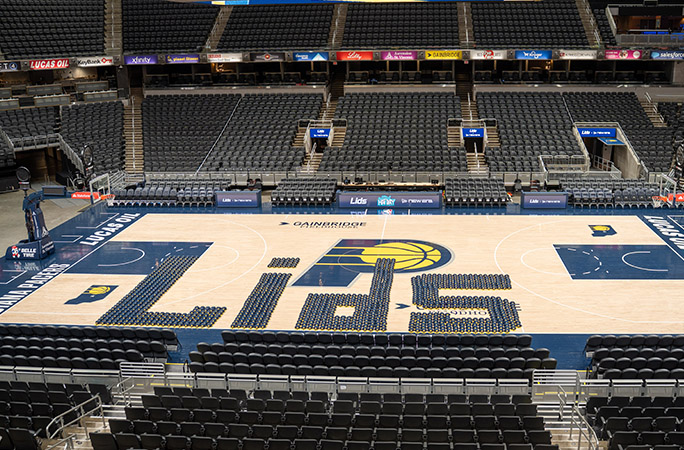 largest hat word spells out lids in blue hats on basketball court