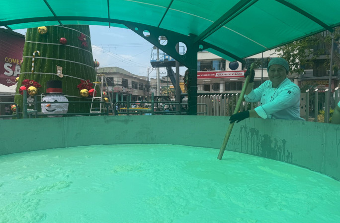 A worker smiling and stirring the cocoa