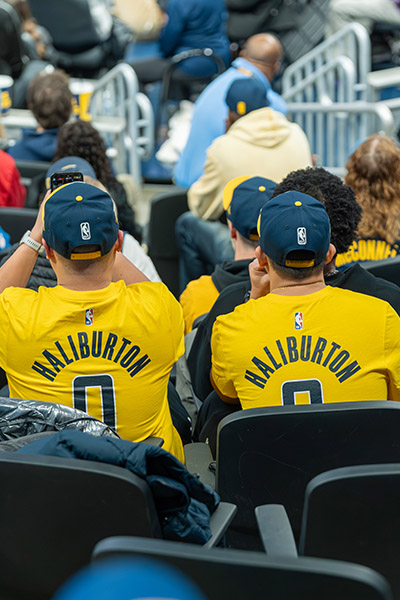 two people with their backs turned wearing yellow jerseys and blue hats