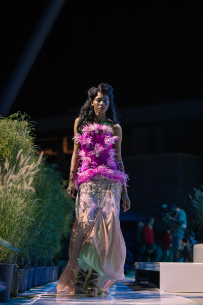 A model walking the runway in a purple dress