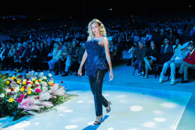 A girl in a black suit walking the runway