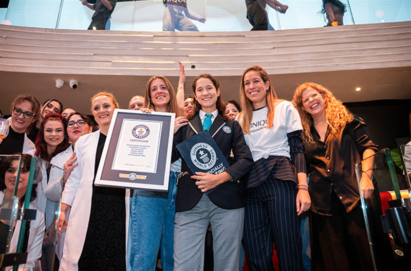 a group of people stand next to each other smiling holding a guinness world records certificate