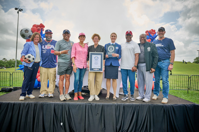 Adjudicator and event organizers holding the certificate