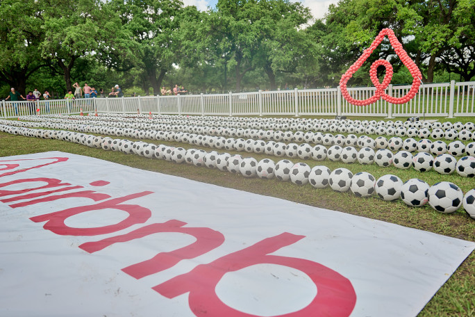 Line of soccer balls in front of the Airbnb logo