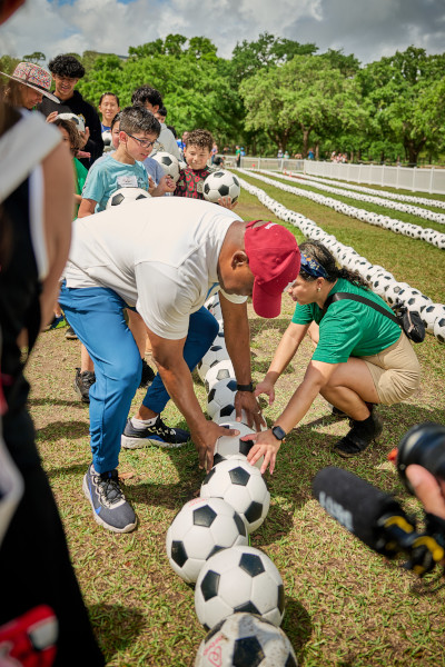 Father and daughter placing soccer balls in the line