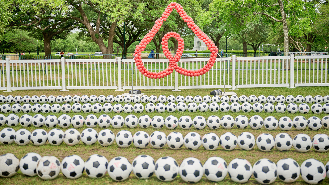 The soccer balls lined up in front of the Airbnb logo