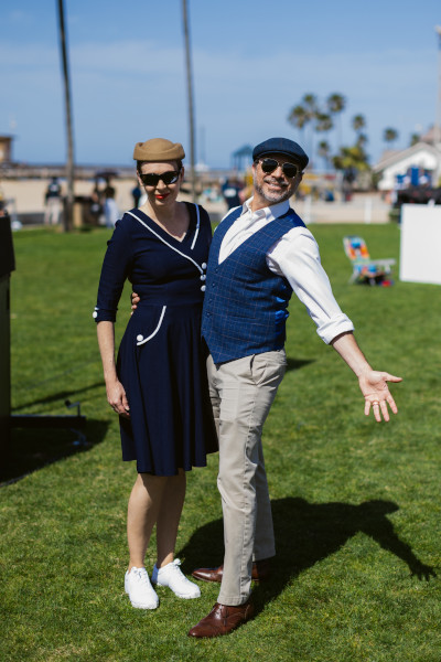 A couple posing for the camera in their vintage outfits