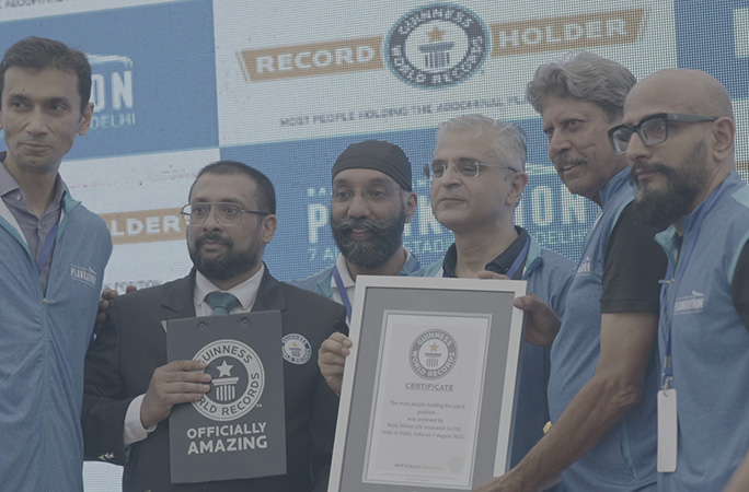 a group of men stand next to each other smiling and holding a guinness world records certificate