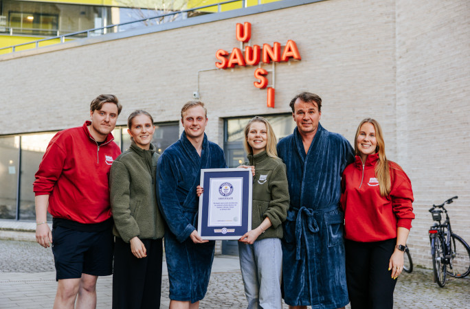 Organizers outside the sauna with their certificate