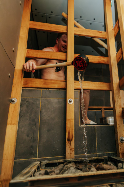 Participant pouring water on coals