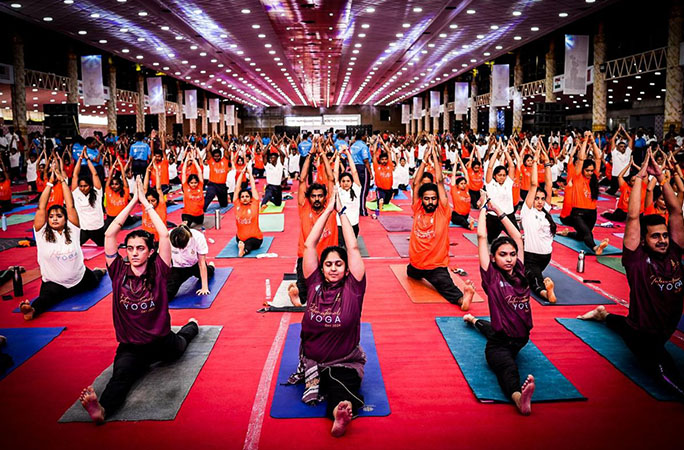 people perform yoga poses in a straight line