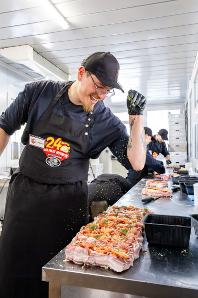 A butcher sprinkling seasoning on the steak